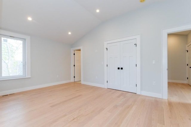 unfurnished bedroom with vaulted ceiling, light wood finished floors, baseboards, recessed lighting, and a closet