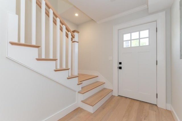 foyer entrance featuring light wood-style flooring, stairway, ornamental molding, and recessed lighting