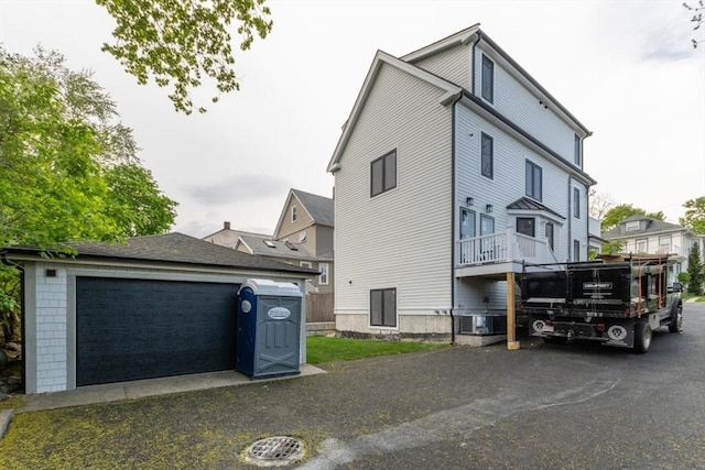 view of side of home featuring an outdoor structure, central air condition unit, and a detached garage