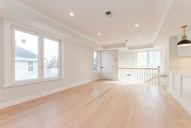 empty room featuring crown molding, a tray ceiling, light wood-style floors, recessed lighting, and baseboards