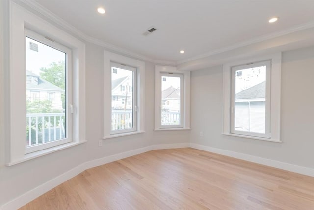 empty room with ornamental molding, light wood-style floors, baseboards, and recessed lighting