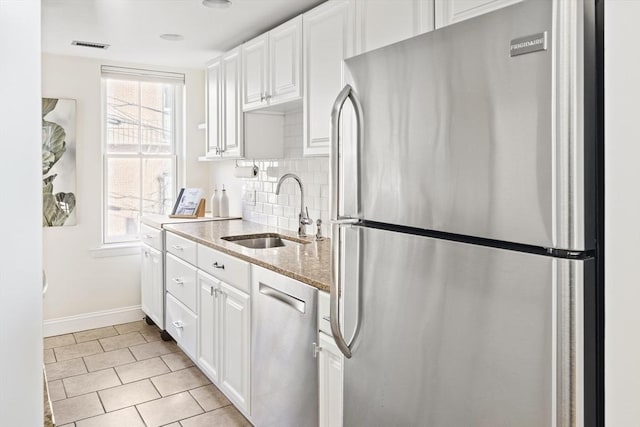 kitchen with backsplash, sink, white cabinetry, and appliances with stainless steel finishes