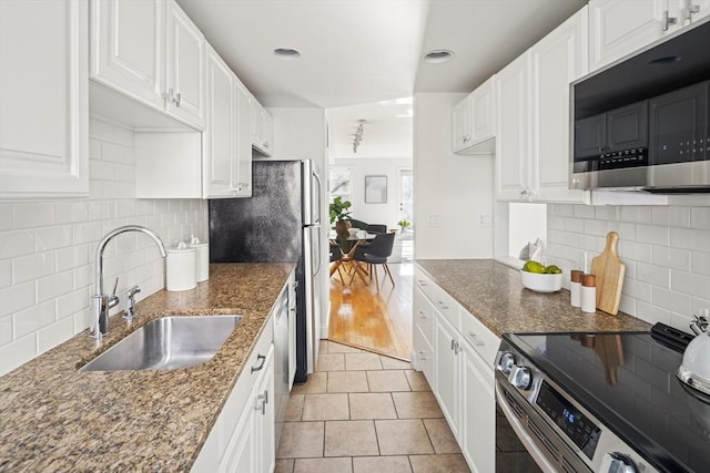 kitchen with light tile patterned floors, white cabinetry, stainless steel appliances, and sink