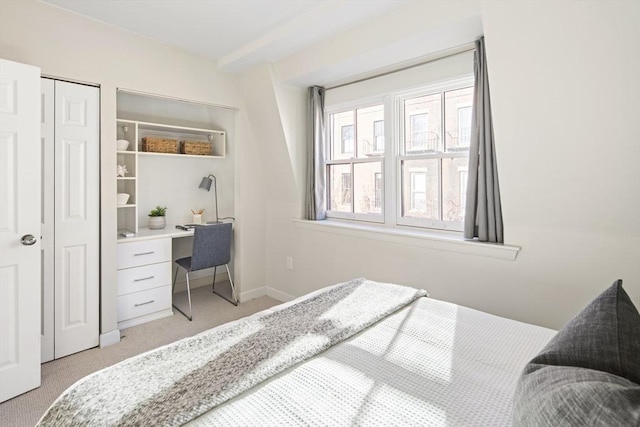 carpeted bedroom with built in desk