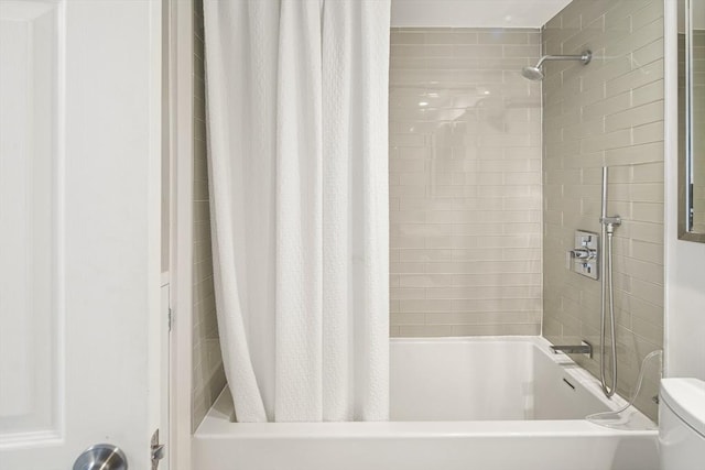 bathroom featuring toilet and shower / bath combo with shower curtain