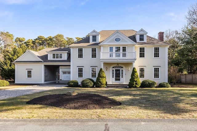 view of front of home featuring a balcony, a garage, and a front lawn