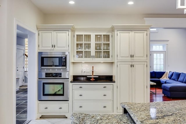 kitchen with light stone counters, white cabinets, and appliances with stainless steel finishes