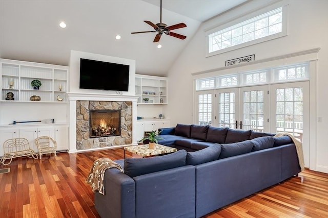 living room featuring a stone fireplace, light hardwood / wood-style flooring, and plenty of natural light