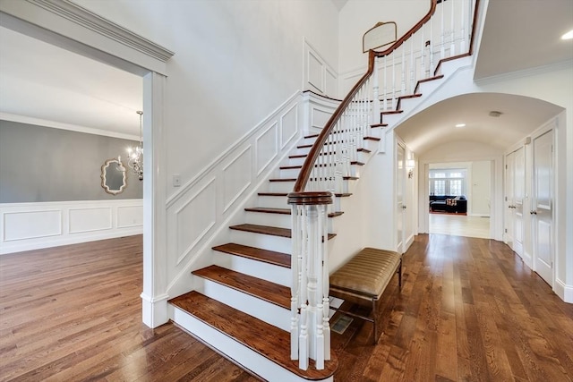 stairway featuring hardwood / wood-style floors, a notable chandelier, and ornamental molding