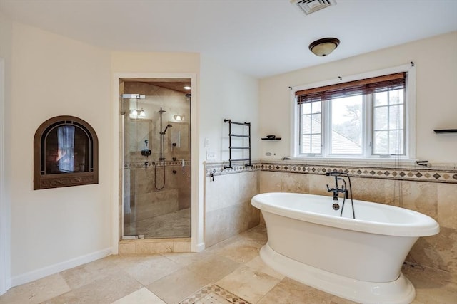 bathroom with tile walls and plus walk in shower