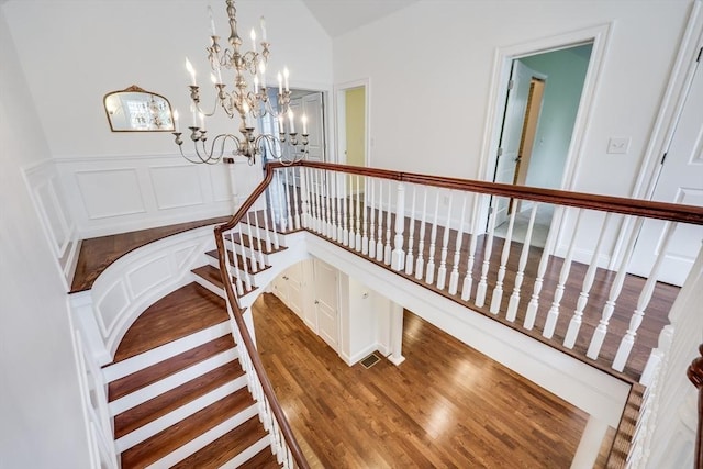 staircase featuring hardwood / wood-style floors and a notable chandelier