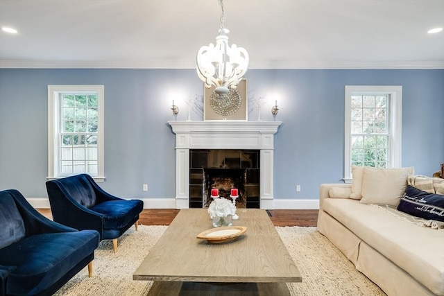 living room with plenty of natural light, wood-type flooring, crown molding, and a tile fireplace