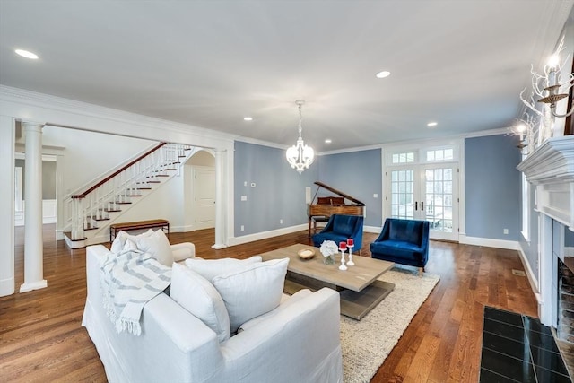 living room with crown molding, hardwood / wood-style floors, a chandelier, and french doors