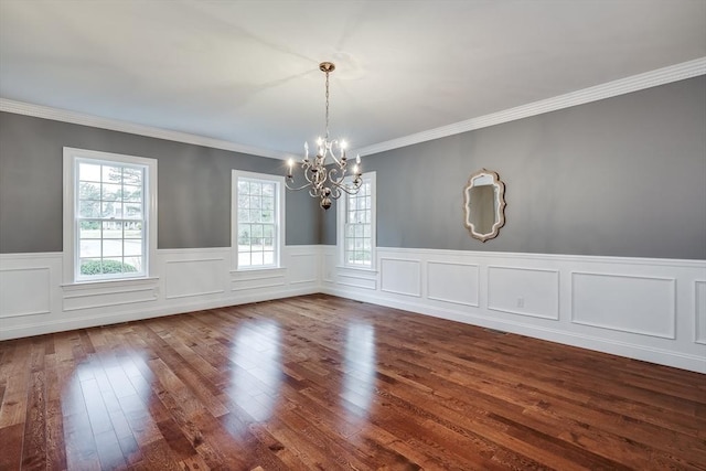 unfurnished dining area with wood-type flooring, crown molding, and a notable chandelier