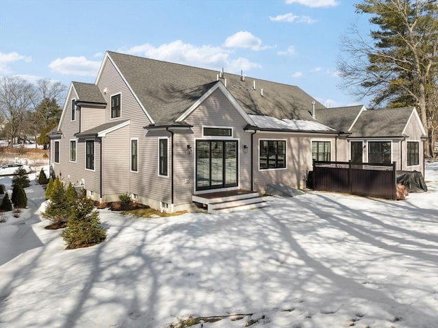 snow covered house with roof with shingles