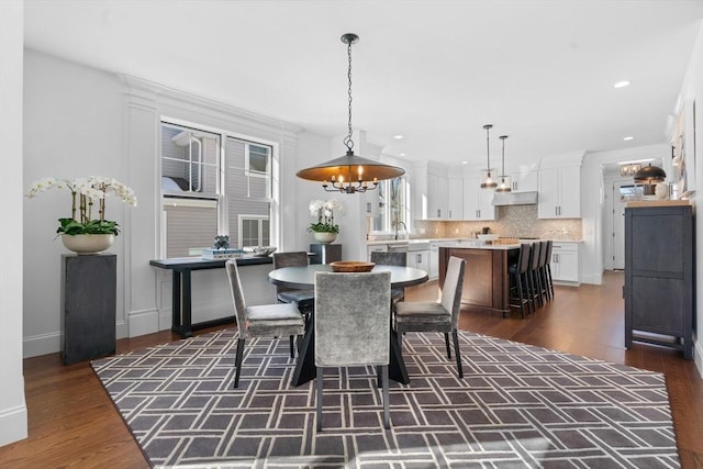 dining space with baseboards, dark wood-style flooring, and recessed lighting