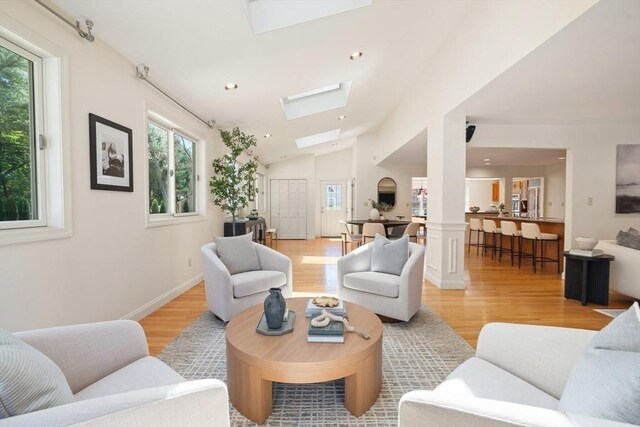 living area featuring recessed lighting, lofted ceiling with skylight, and light wood-style floors