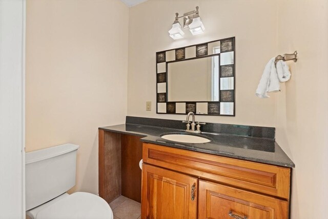 bathroom featuring vanity, tile patterned floors, and toilet