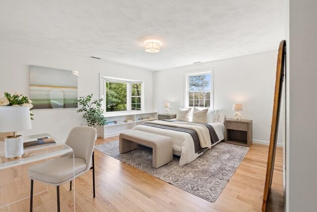 bedroom featuring visible vents and wood finished floors