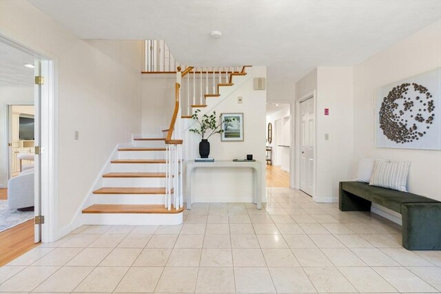 stairway with baseboards and tile patterned flooring