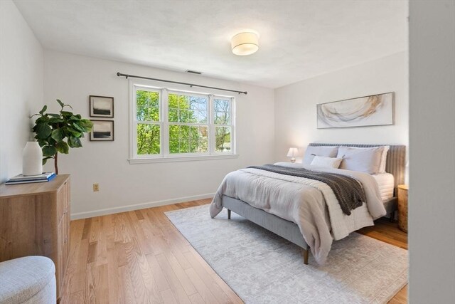 bedroom featuring baseboards and light wood finished floors
