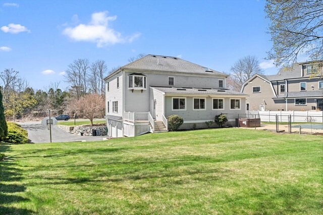 back of house featuring fence and a lawn