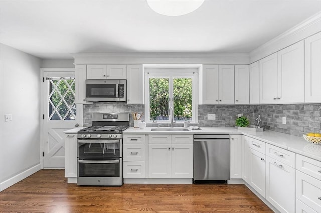 24 Gerald Rd, Marblehead, MA 01945 - kitchen featuring stainless steel appliances, backsplash, white cabinets, light countertops, and dark wood-style flooring