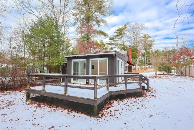 snow covered house with a wooden deck