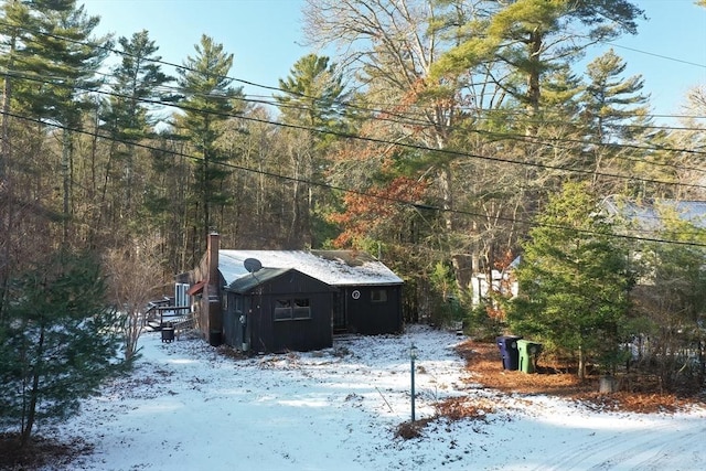 view of snowy exterior with a storage shed