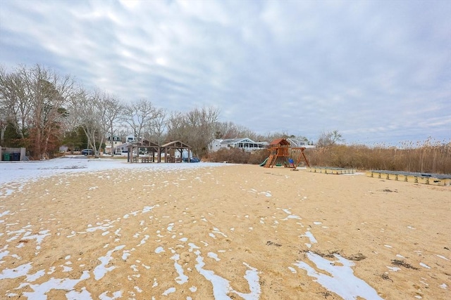 yard layered in snow featuring a playground