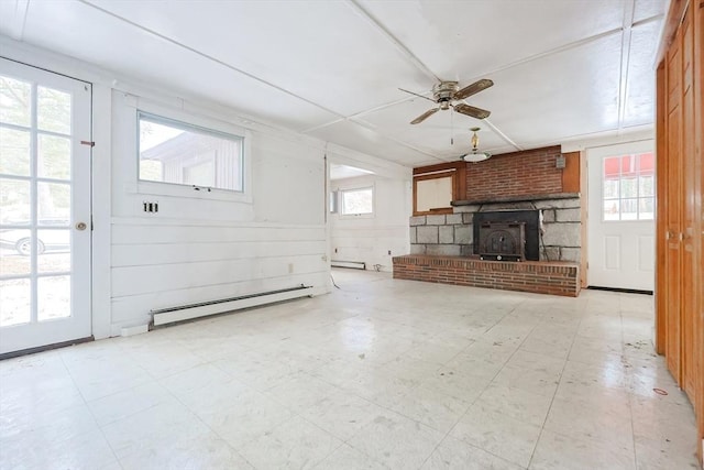 unfurnished living room featuring a baseboard heating unit, ceiling fan, and a wood stove