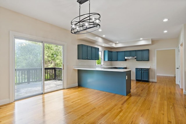 20 Miller St, Rehoboth, MA 02769 - kitchen featuring under cabinet range hood, blue cabinetry, a peninsula, a chandelier, and light wood finished floors