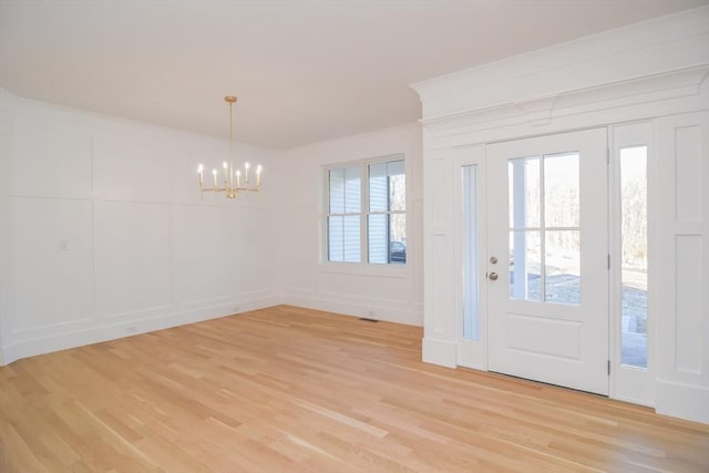 foyer entrance featuring an inviting chandelier and light wood-type flooring