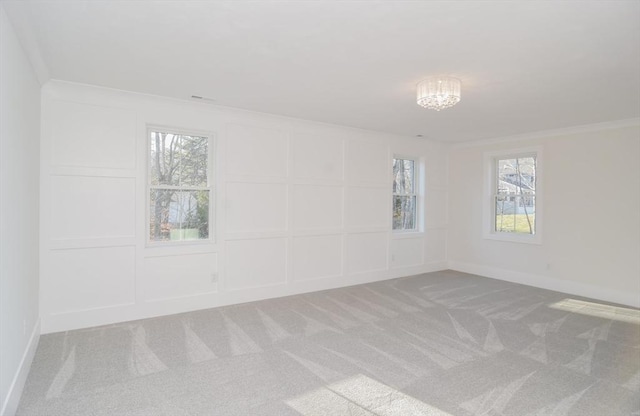 empty room featuring ornamental molding, an inviting chandelier, and carpet floors