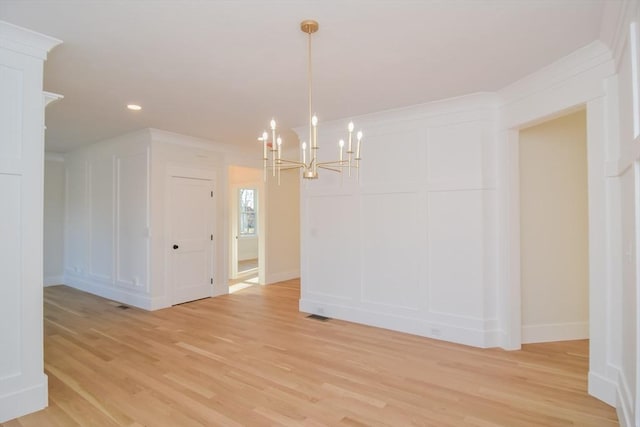 unfurnished dining area with light hardwood / wood-style floors and a chandelier