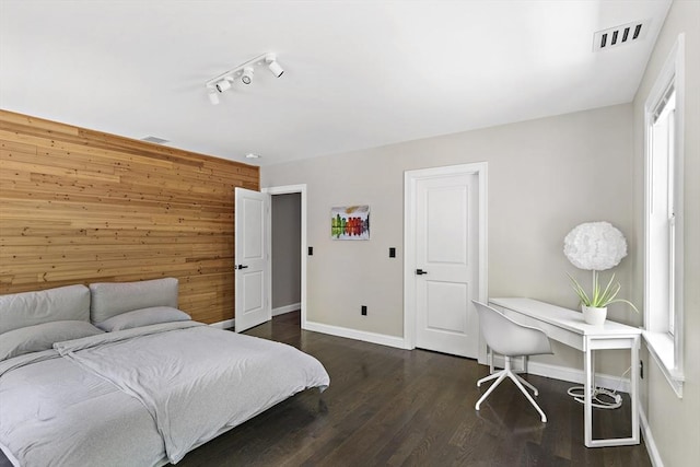 122 Green St, Northborough, MA 01532 - bedroom featuring baseboards, dark wood-style flooring, wooden walls, and rail lighting