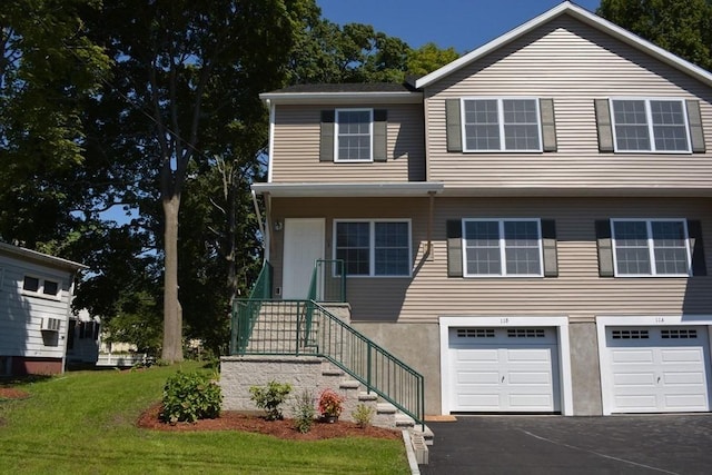 view of front of property featuring stairway, a front yard, an attached garage, and driveway