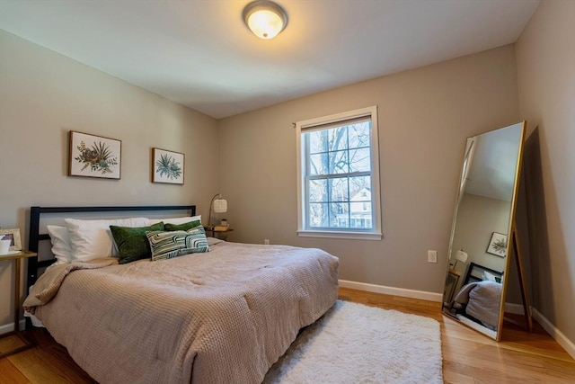 bedroom with light wood-type flooring and baseboards