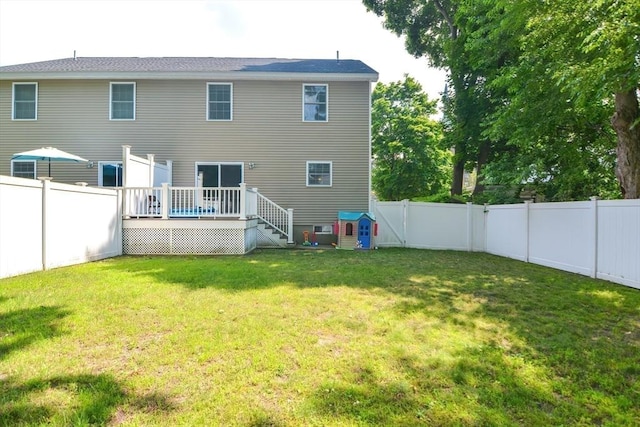 back of house with a yard, a wooden deck, and a fenced backyard