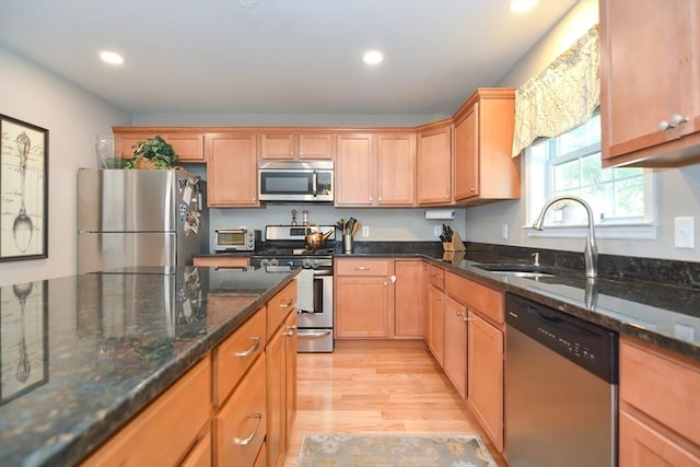 kitchen with a sink, recessed lighting, light wood-style floors, and stainless steel appliances