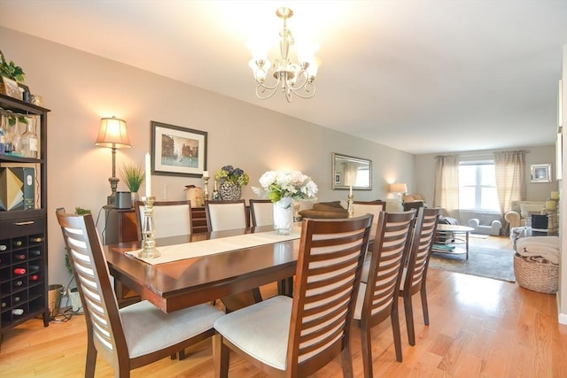 dining space with light wood-style floors and a chandelier