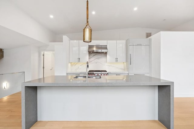 kitchen featuring sink, white cabinetry, vaulted ceiling, paneled built in fridge, and decorative backsplash