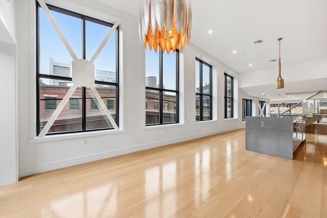 unfurnished living room with a healthy amount of sunlight and light hardwood / wood-style floors