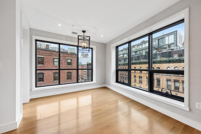 interior space featuring a notable chandelier, light wood-type flooring, and a wealth of natural light