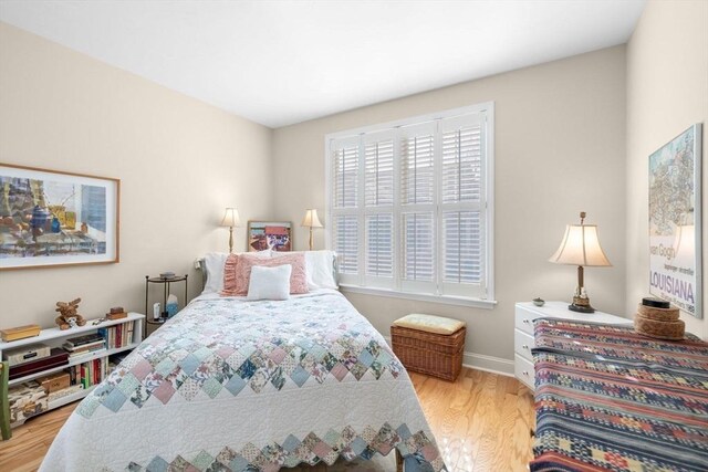 bedroom with baseboards and wood finished floors