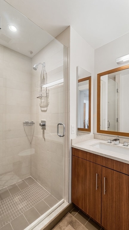 bathroom with tile floors, an enclosed shower, and vanity