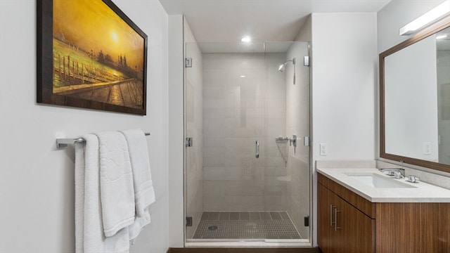 bathroom with vanity with extensive cabinet space and a shower with door