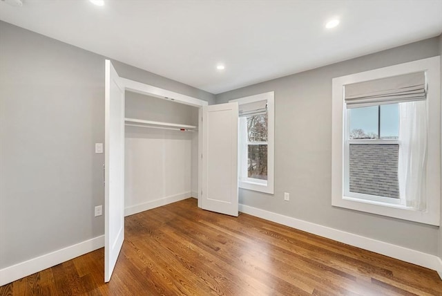 unfurnished bedroom with hardwood / wood-style floors and a closet