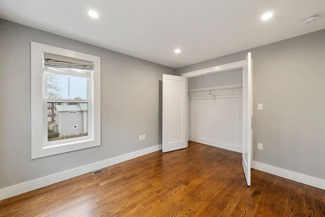 unfurnished bedroom with hardwood / wood-style floors and a closet