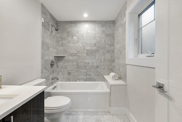 full bathroom featuring vanity, tiled shower / bath combo, and toilet